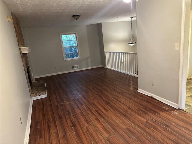 unfurnished room featuring dark hardwood / wood-style floors and a textured ceiling