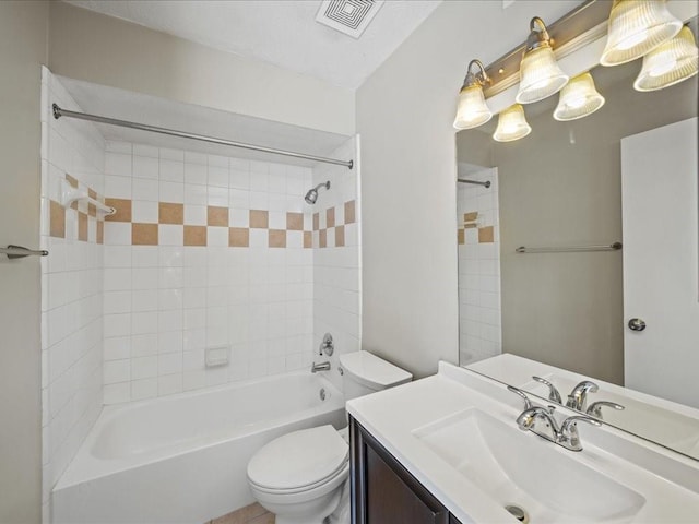 full bathroom with vanity, tiled shower / bath combo, and toilet