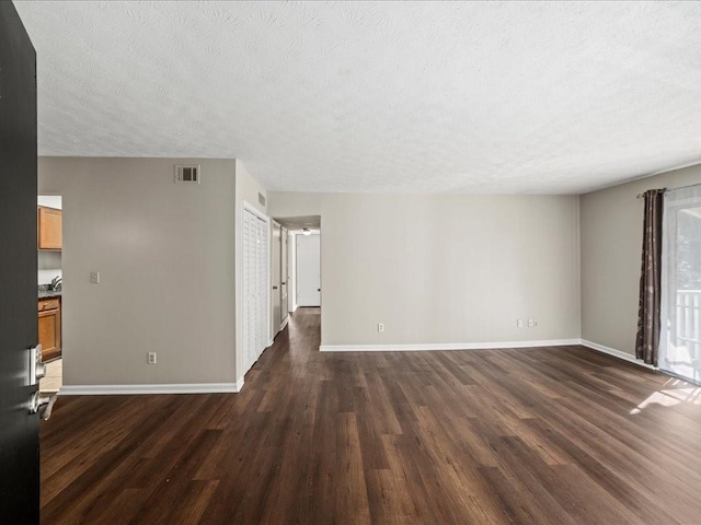 empty room featuring dark wood-type flooring and a textured ceiling