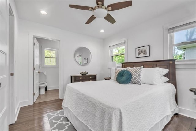 bedroom featuring dark wood-style flooring, baseboards, and multiple windows
