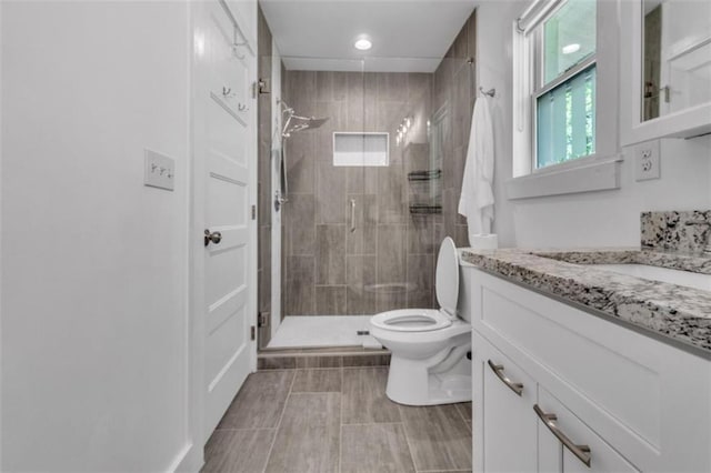 bathroom featuring toilet, a shower stall, vanity, and recessed lighting