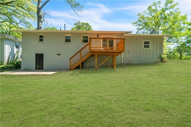 rear view of property featuring stairs, a deck, board and batten siding, and a lawn