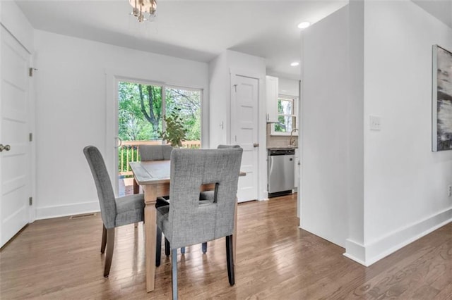 dining room featuring baseboards, recessed lighting, wood finished floors, and a healthy amount of sunlight