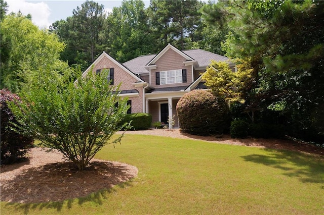 craftsman-style home with a front yard and brick siding