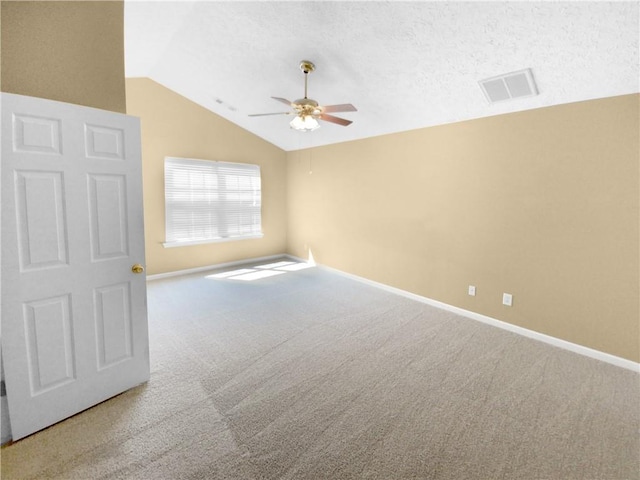 carpeted empty room with lofted ceiling, ceiling fan, and a textured ceiling