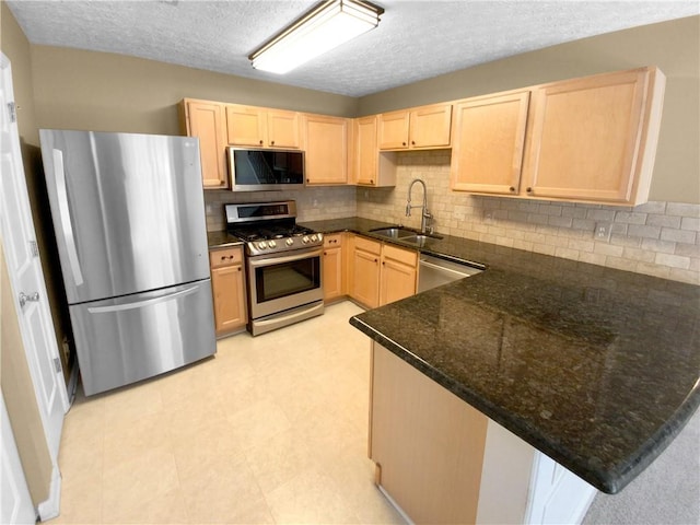 kitchen featuring light brown cabinets, sink, appliances with stainless steel finishes, and kitchen peninsula