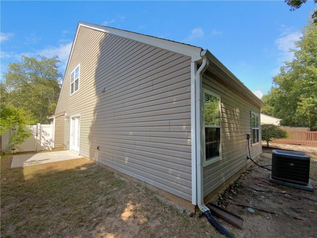 view of side of property with cooling unit and a patio area