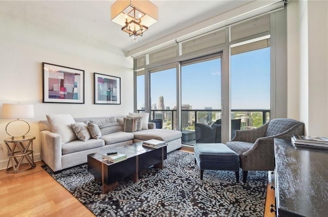 living area with a view of city, baseboards, wood finished floors, and an inviting chandelier