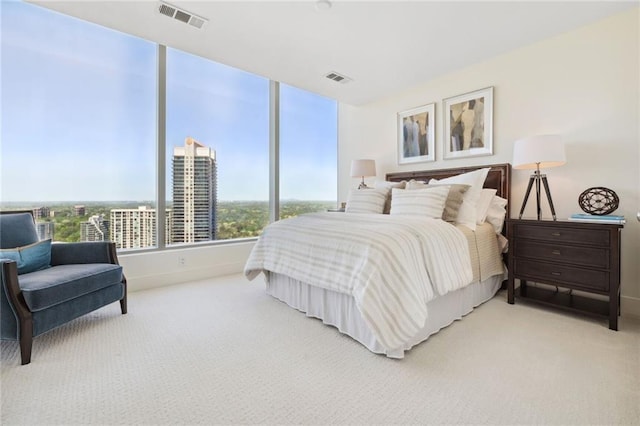 bedroom featuring visible vents and light colored carpet