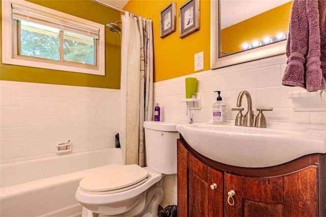 full bathroom featuring tile walls, toilet, vanity, and a wainscoted wall