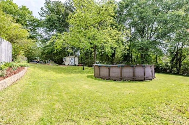view of yard featuring an outbuilding, an outdoor pool, and a storage unit