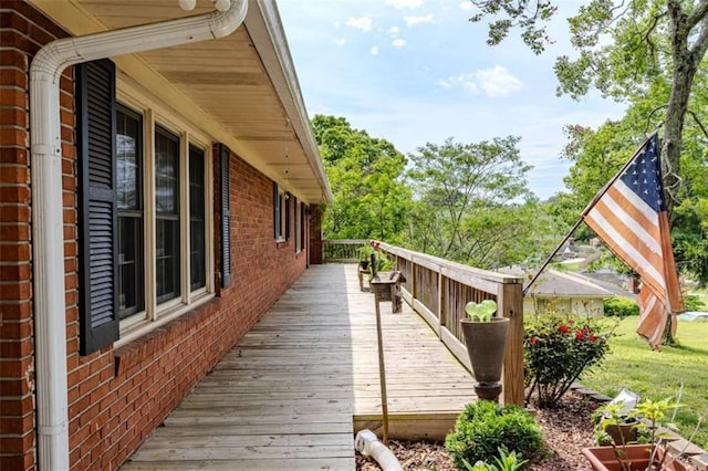 view of home's exterior with brick siding and a wooden deck