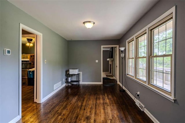 interior space with a wealth of natural light, visible vents, and wood finished floors