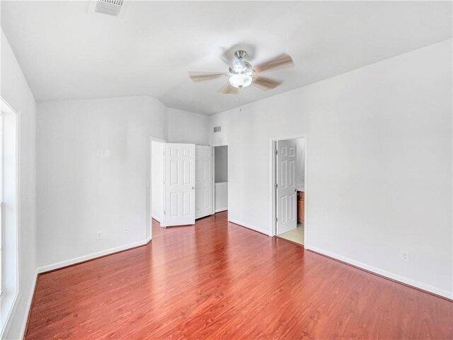 spare room featuring visible vents, wood finished floors, baseboards, and ceiling fan