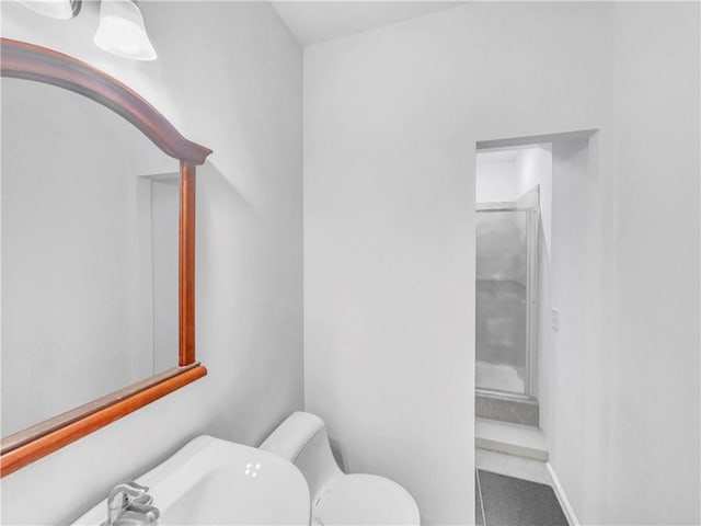 bathroom featuring a walk in shower and toilet