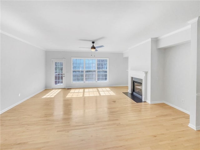unfurnished living room featuring ceiling fan, a fireplace with flush hearth, light wood-style flooring, and crown molding