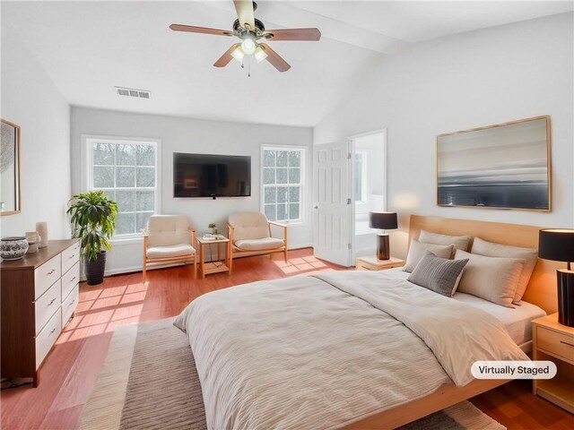 bedroom featuring light wood finished floors, visible vents, multiple windows, and vaulted ceiling