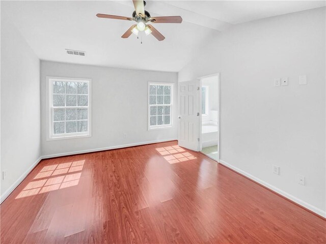 empty room with visible vents, plenty of natural light, ceiling fan, and wood finished floors