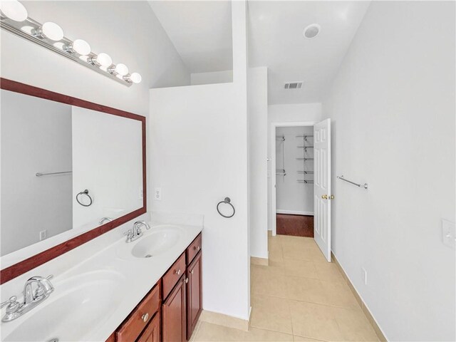 full bath featuring a sink, visible vents, double vanity, and tile patterned floors