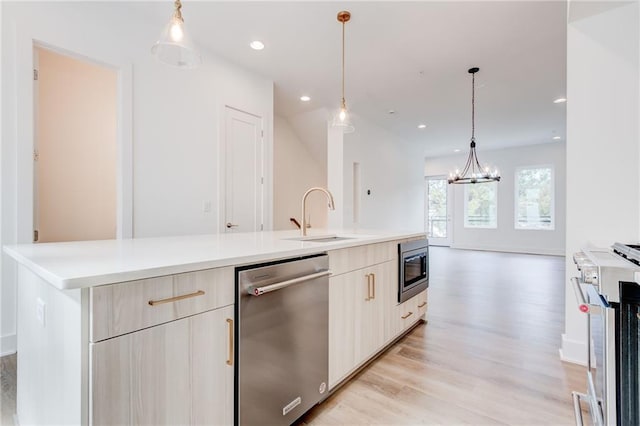 kitchen featuring sink, hanging light fixtures, a spacious island, and appliances with stainless steel finishes