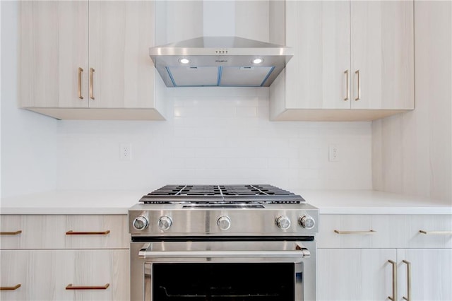 kitchen with stainless steel range with gas stovetop, decorative backsplash, and wall chimney exhaust hood