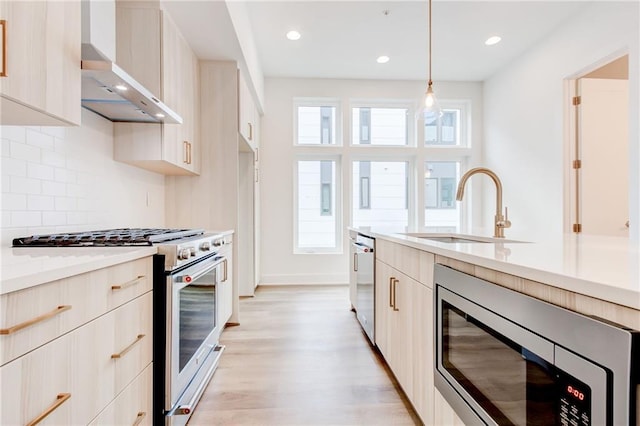 kitchen featuring sink, appliances with stainless steel finishes, backsplash, decorative light fixtures, and wall chimney exhaust hood