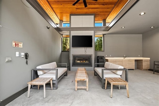 view of patio / terrace featuring ceiling fan and an outdoor living space with a fireplace