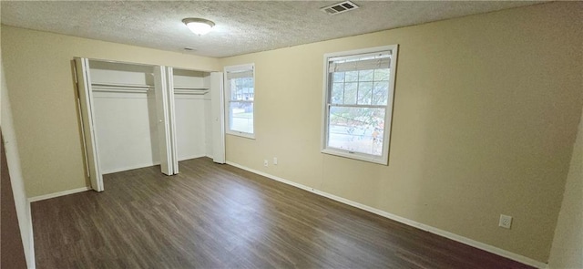 5595 Marbut Rd, Lithonia, GA 30058 - unfurnished bedroom with dark wood finished floors, a textured ceiling, and a closet