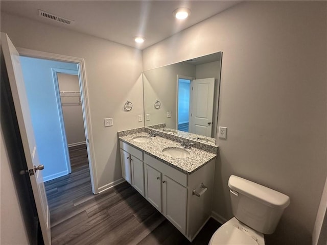 8664 Webb Rd, Riverdale, GA 30274 - bathroom featuring wood finished floors, double vanity, toilet, recessed lighting, and baseboards
