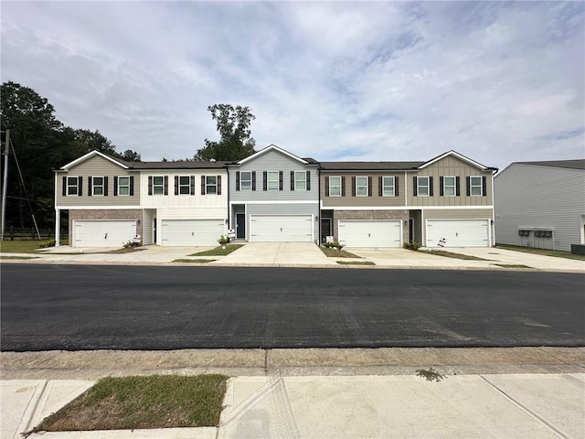 8664 Webb Rd, Riverdale, GA 30274 - townhome / multi-family property with an attached garage, board and batten siding, and driveway