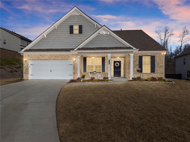 craftsman-style home featuring brick siding, a lawn, a porch, and concrete driveway