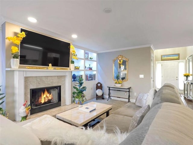 living room with a tile fireplace and crown molding