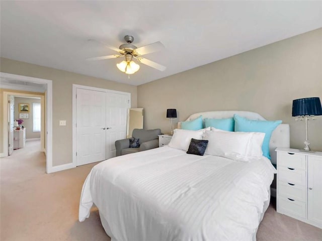 carpeted bedroom with ceiling fan and a closet