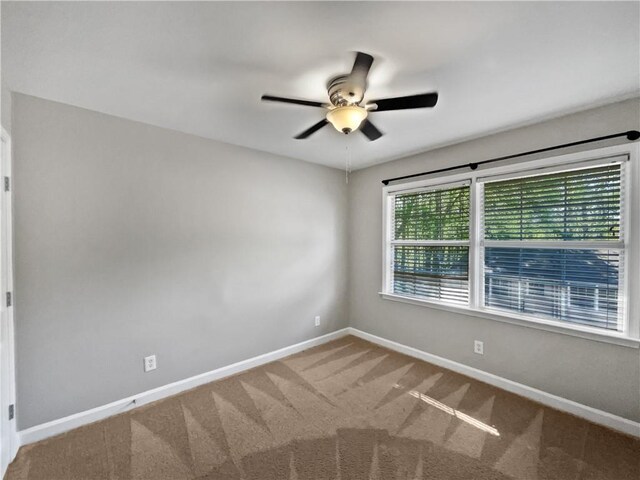 carpeted empty room featuring ceiling fan