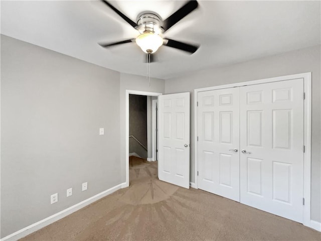 unfurnished bedroom with light colored carpet, a closet, and ceiling fan