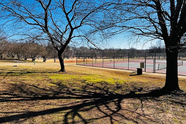 view of home's community featuring tennis court