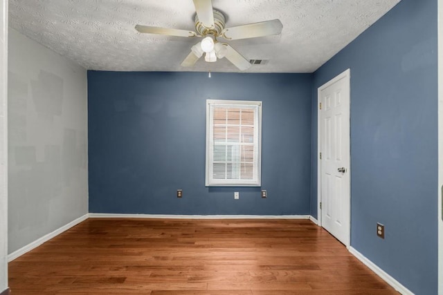 spare room with hardwood / wood-style floors, a textured ceiling, and ceiling fan