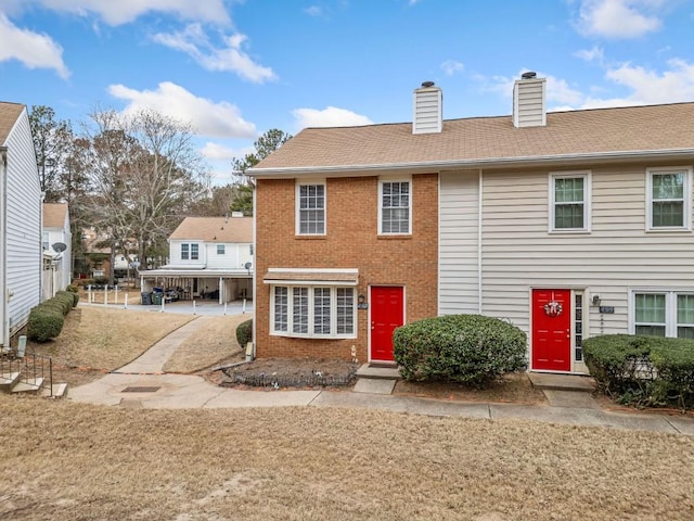 view of front of property with a chimney and brick siding