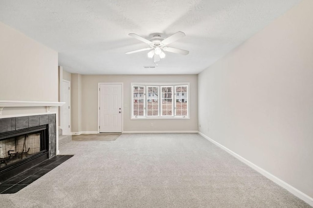 unfurnished living room with carpet, a fireplace, visible vents, and baseboards