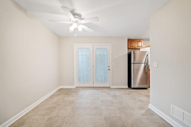 spare room with visible vents, ceiling fan, and baseboards