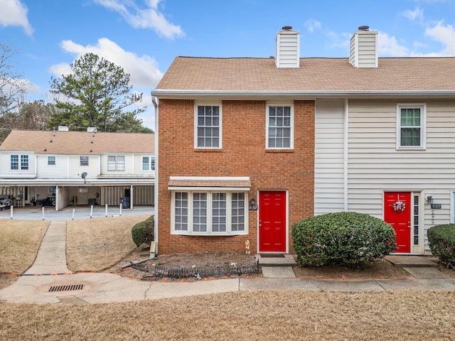 view of front of property with brick siding and a chimney