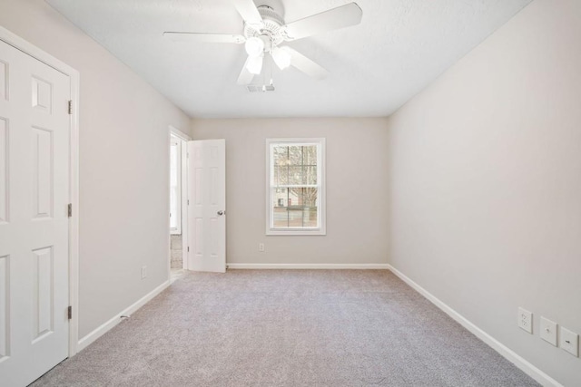 spare room featuring carpet floors, baseboards, and a ceiling fan