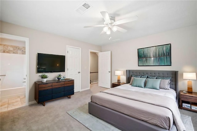 carpeted bedroom with visible vents, connected bathroom, baseboards, and ceiling fan