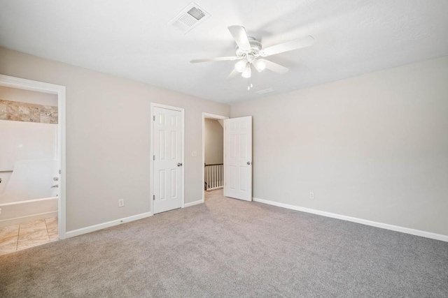 unfurnished bedroom with baseboards, visible vents, carpet flooring, and ensuite bathroom