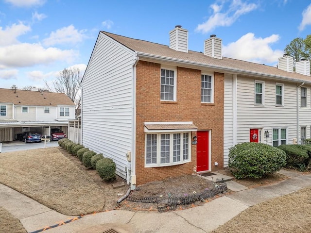 townhome / multi-family property with brick siding and a chimney