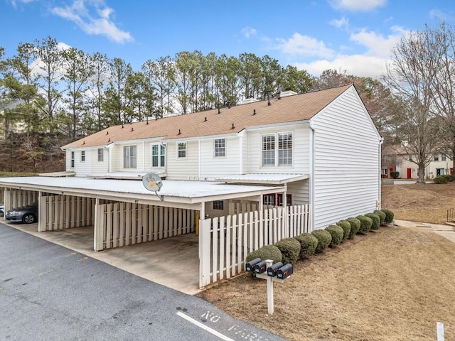 view of front of house with covered parking and a shingled roof