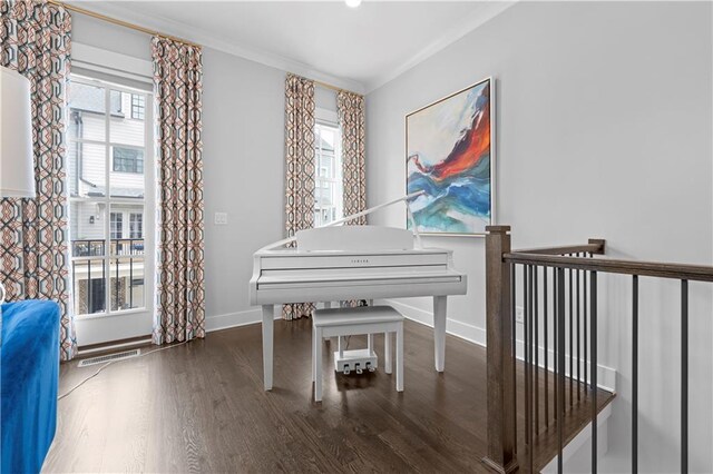 sitting room featuring dark wood-style floors, a wealth of natural light, ornamental molding, and baseboards