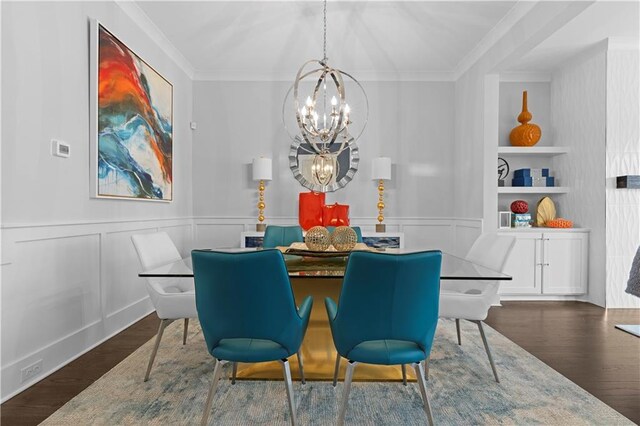 dining room featuring dark wood-style floors, built in features, crown molding, and an inviting chandelier