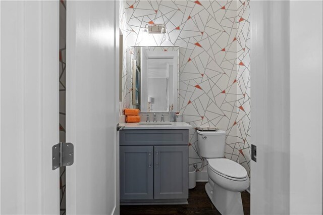 bathroom with tile walls, vanity, and toilet