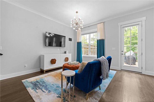 living room featuring dark wood-style floors, baseboards, ornamental molding, and an inviting chandelier